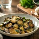 Aubergines à la poêle à l'ail, dorées et fondantes, servies avec du persil plat frais et un filet d'huile d'olive vierge extra