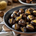 Châtaignes incisées en croix dorées au four sur une plaque, servies chaudes avec un torchon, ambiance automne